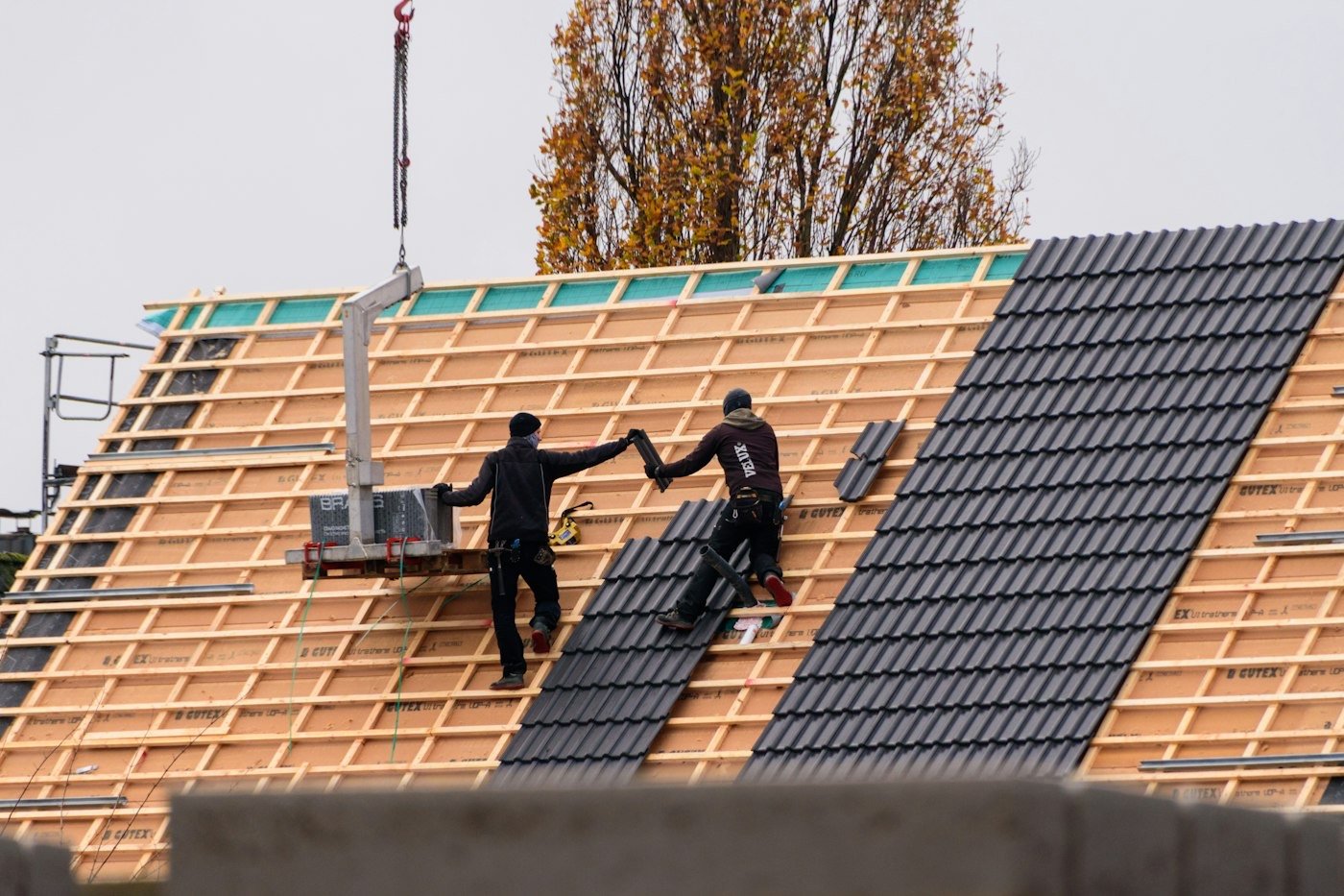 Couvreurs de Toiture En Ligne posant des tuiles sur une toiture neuve