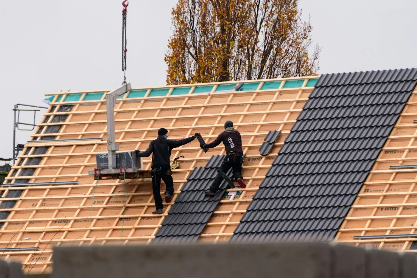 Couvreurs de Toiture En Ligne posant des tuiles sur une toiture neuve