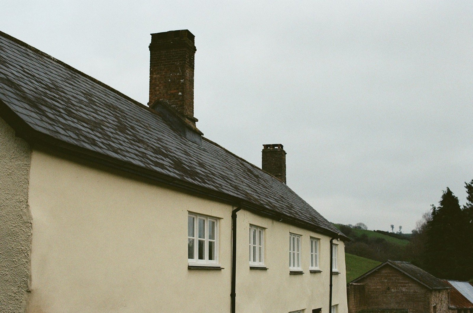 Maison crème avec toiture sombre et cheminées