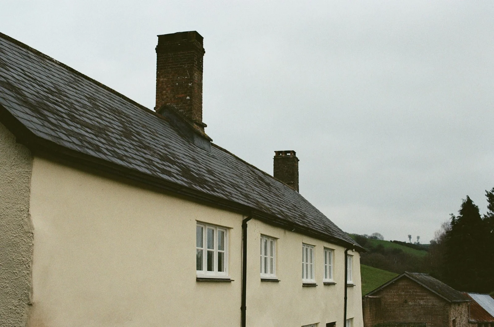 Maison crème avec toiture sombre et cheminées