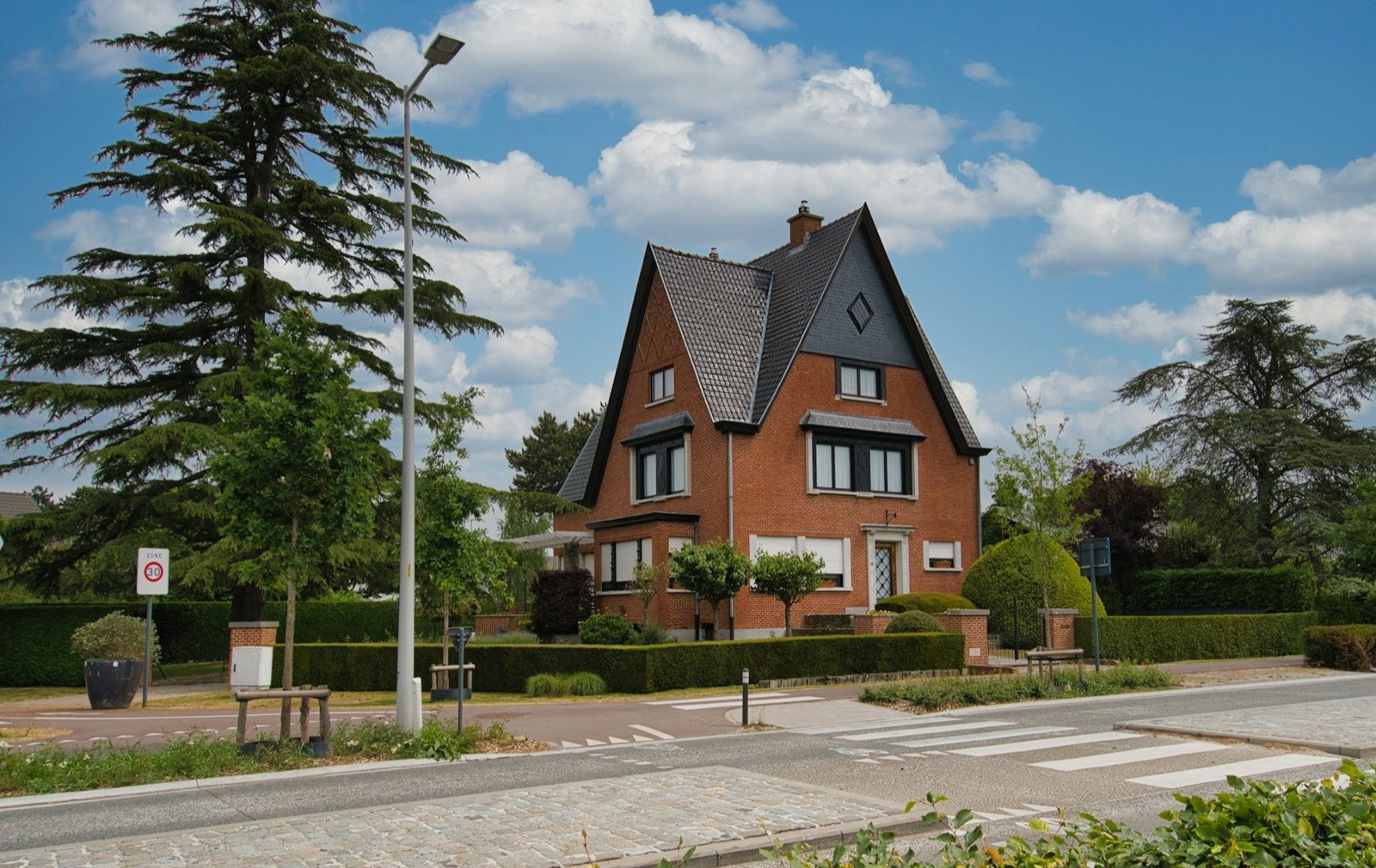 Villa en briques au toit d'ardoises très pentu