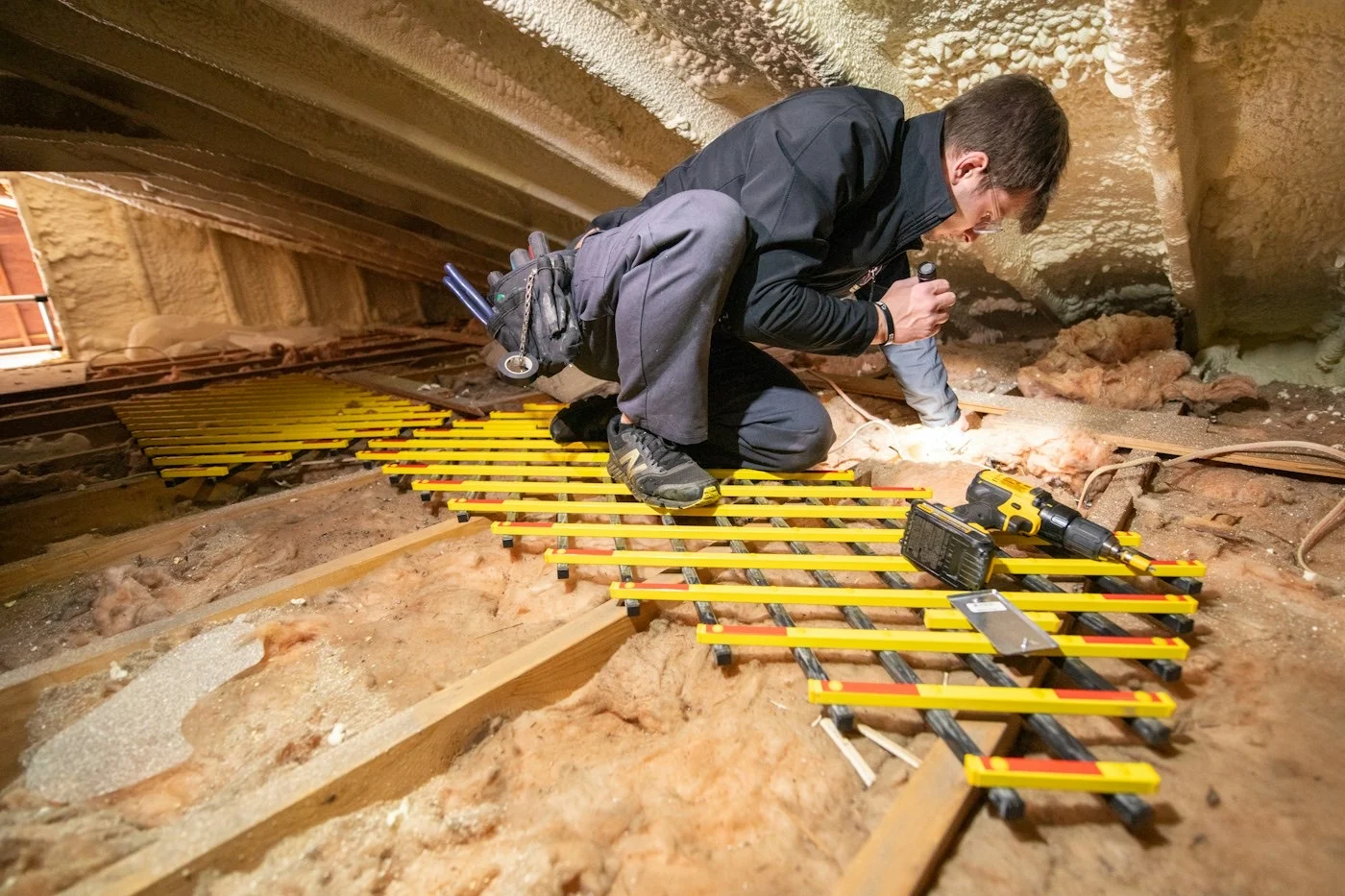 Pose de panneaux isolants dans un grenier lors d'une isolation de toiture