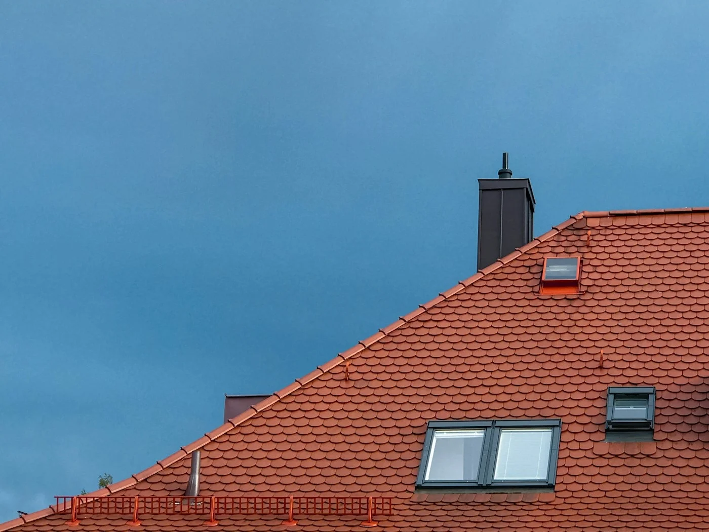 Toiture en tuiles rouges sous un ciel bleu